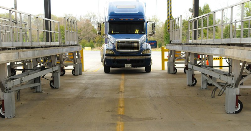 A blue truck parking inside the confines of a loading safety system