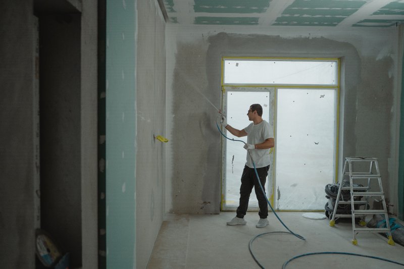 A contractor painting the interior of an office
