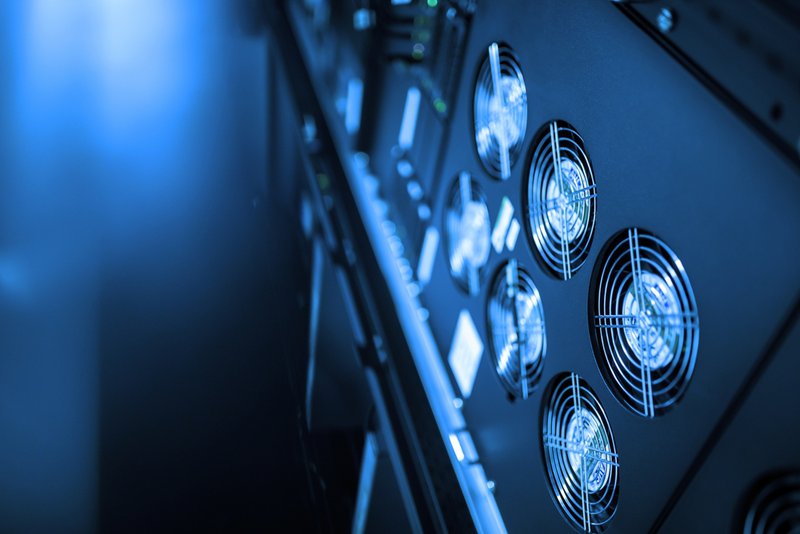 Data center cold aisle with perforated floor tiles, blanking panels, and airflow management components supporting efficient cooling performance.