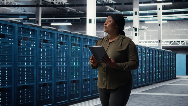 This photo shows a data center administrator performing a routine inspection to identify early signs of rust and moisture damage near critical cooling infrastructure.