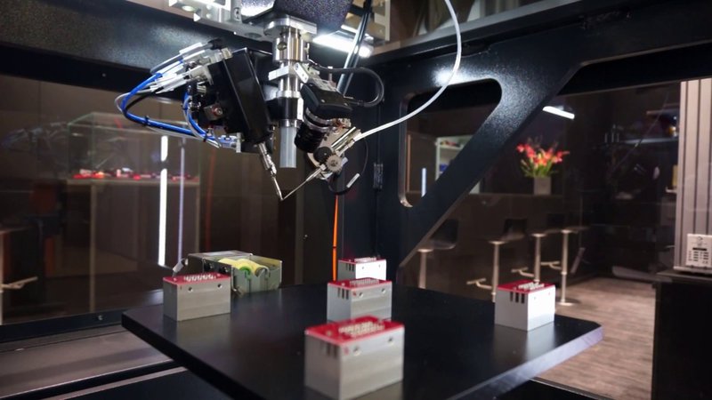 This photo shows an automated soldering robot that has a few items lined up for it to work on.