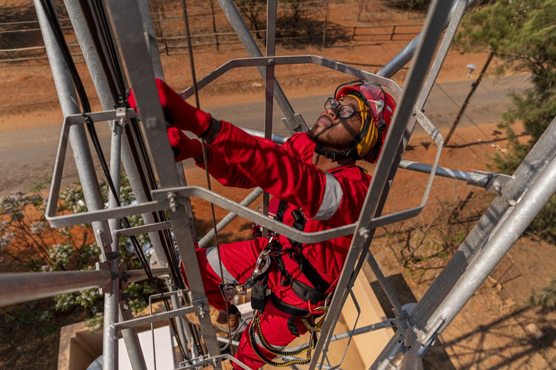 a worker climbing the ladder securely with vertical lifeline