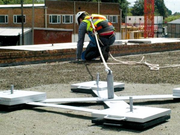 A worker on the roof attached to an anchor
