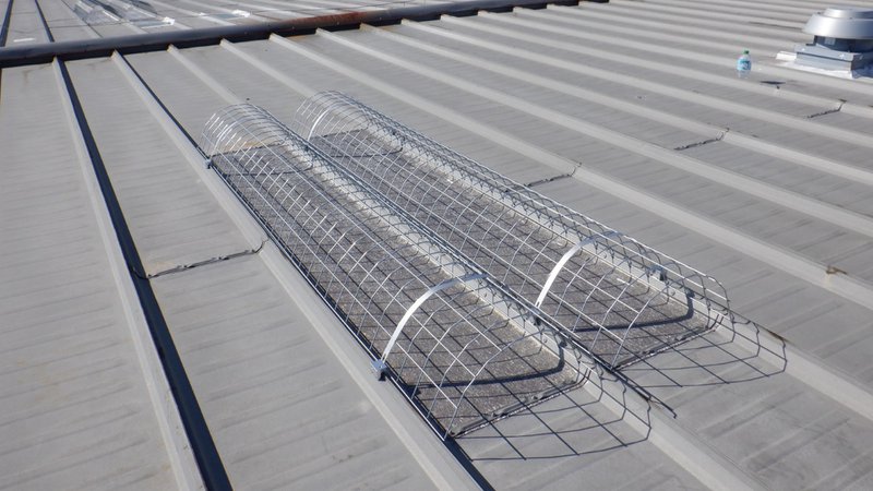 Skylight safety screens installed on a metal roof for construction projects with rooftop openings