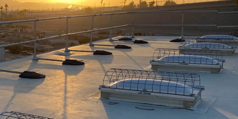 Skylight screens and perimeter guardrails on a commercial flat roof meeting OSHA roofing standards