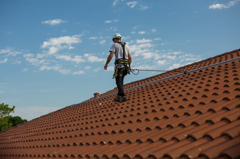 A worker on the roof using a fall arrest system