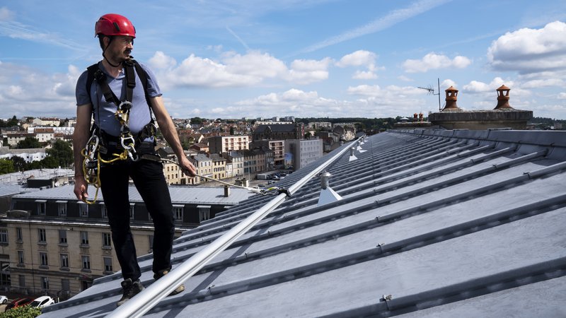 The image shows the NextGen SecuRail Horizontal Lifeline being used on a rooftop.