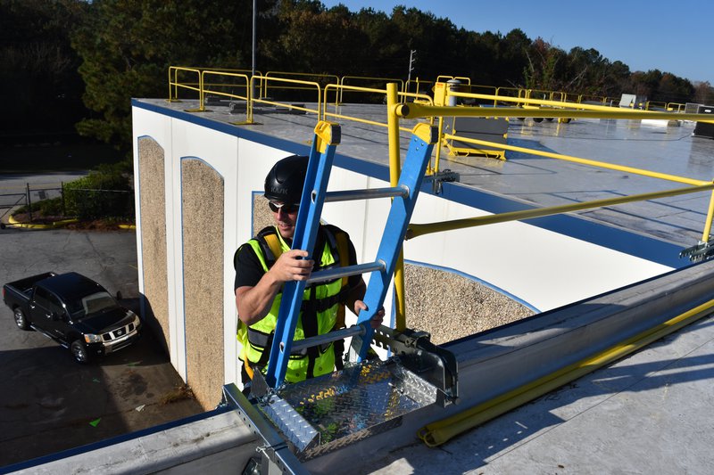A photo of a main climbing a ladder.