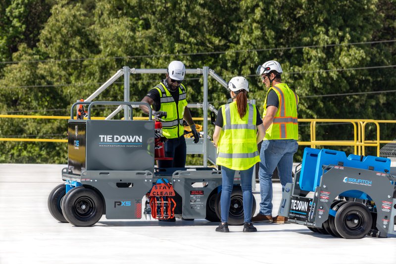 A Team reviews mobile fall protection equipment on a flat rooftop