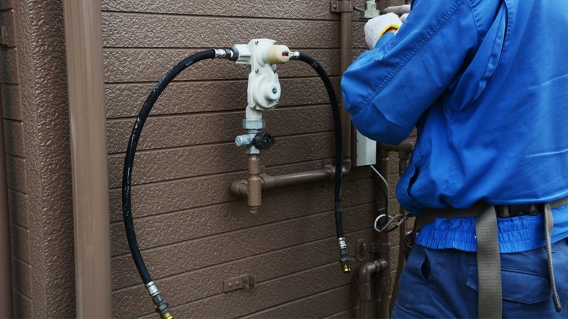 A worker servicing a gas meter on a system configured with a Propane Pipe Sizing Calculator.