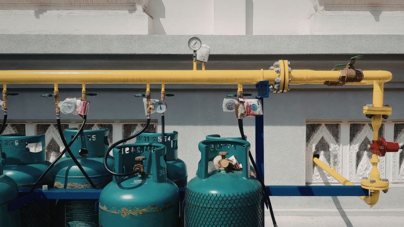 Teal propane tanks connected to a pipeline layout designed using a Propane Pipe Sizing Calculator.