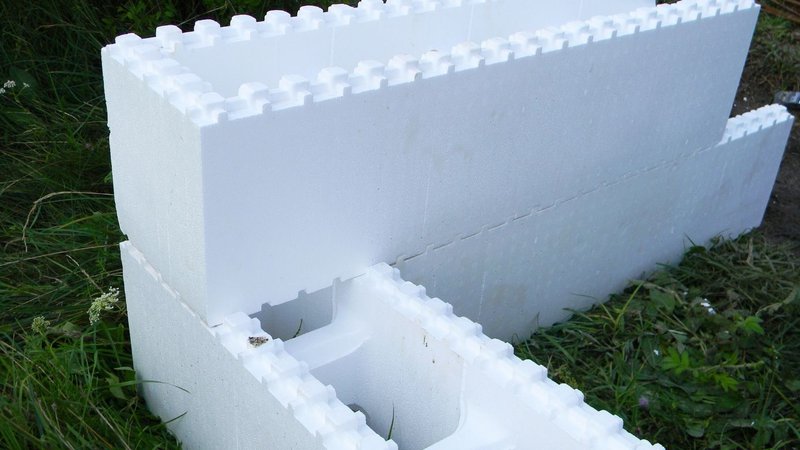 A stack of interlocking white insulation blocks comparing material performance to the U Value of Wood.