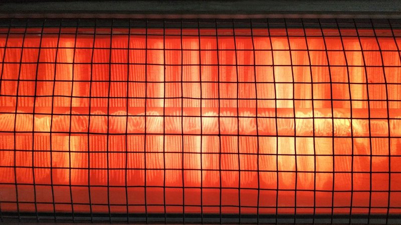 A close-up view of a commercial infrared heater element glowing brightly.