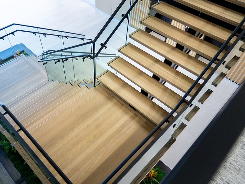 The image shows a wooden staircase while the floors use white oak.