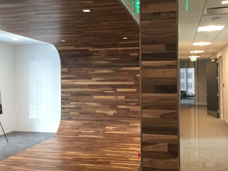 The image shows a curved wood plank accent wall that was installed by Woodwright.