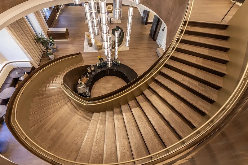 This photo features a spiral staircase in the middle of a lobby