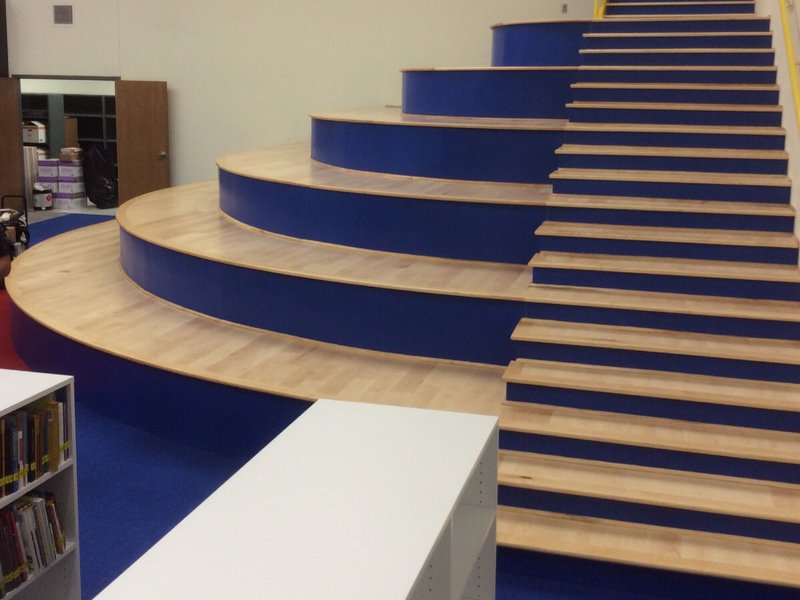 This photo displays a college lobby with a massive custom staircase