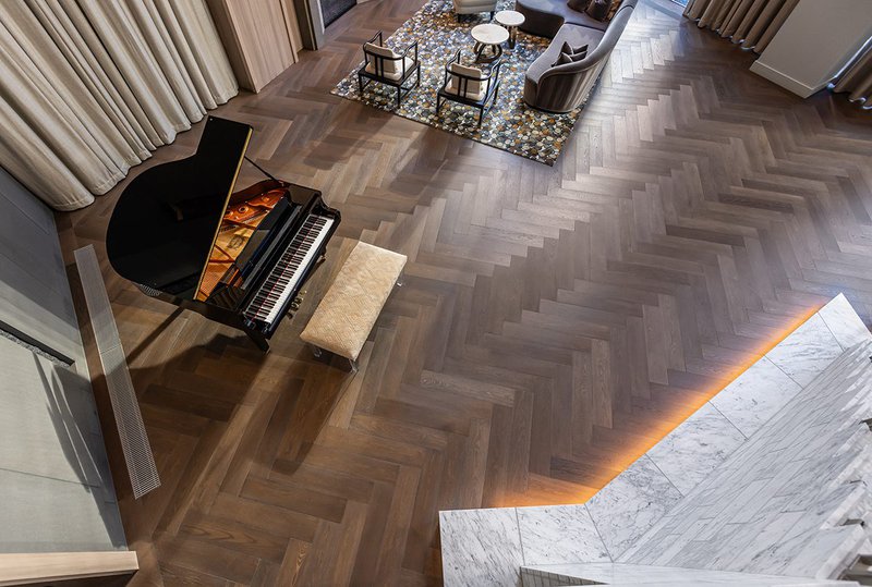 This photo features a hotel lobby with a custom chevron and custom cut wood pattern flooring
