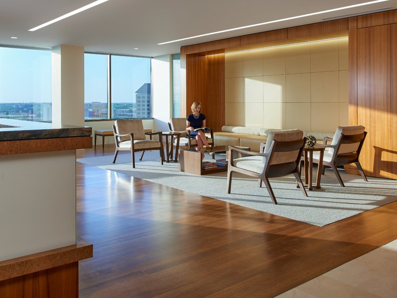 This photo features a lobby that uses wood fabrication to match the finish of the walls to the floors