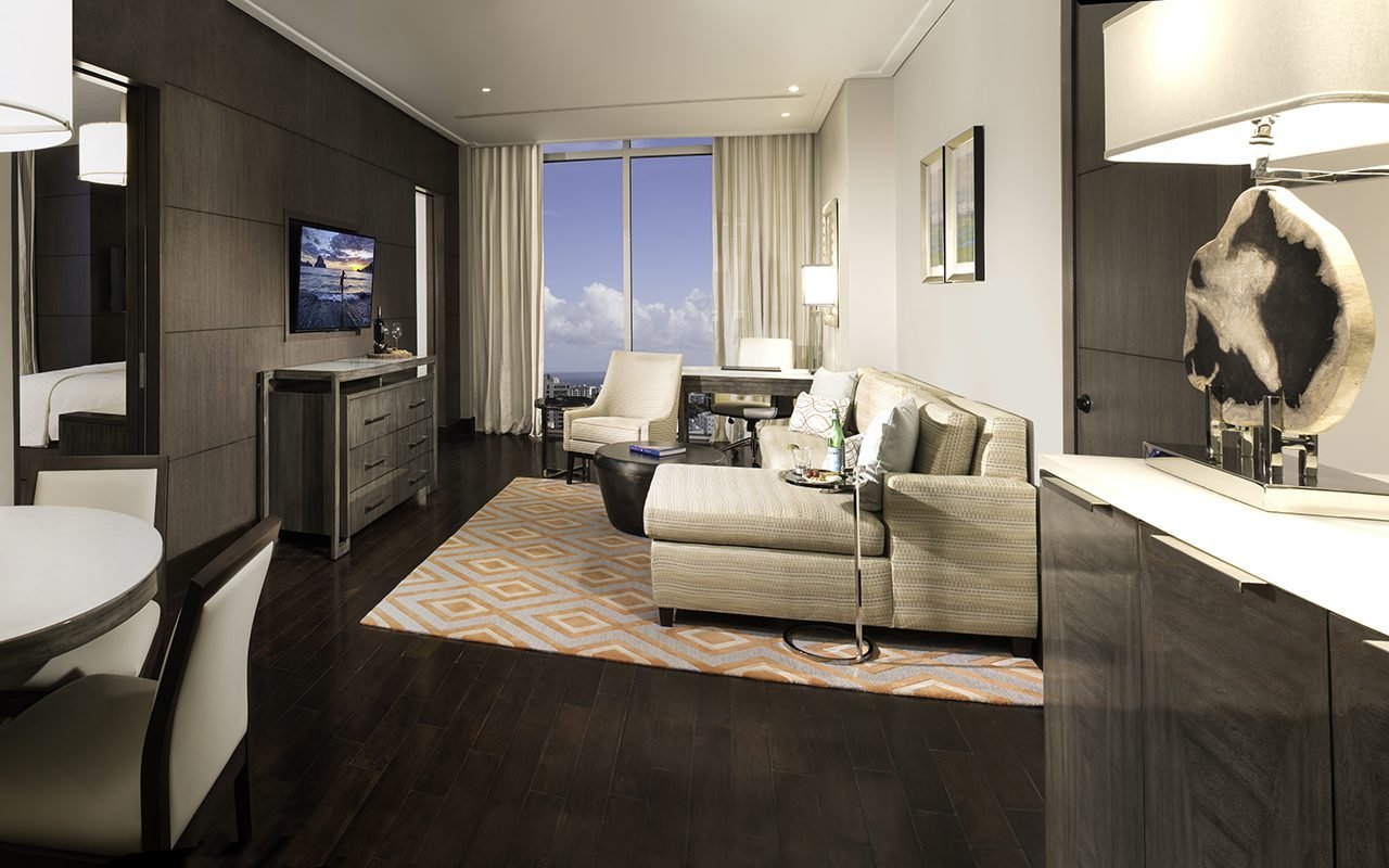 The image shows a hotel room that uses Texas Mesquite wood flooring and is adorned by furnitures such as a couch, cabinets, a chair, and others. The image shows a hotel room that uses Texas Mesquite wood flooring and is adorned by furnitures such as a couch, cabinets, a chair, and others.