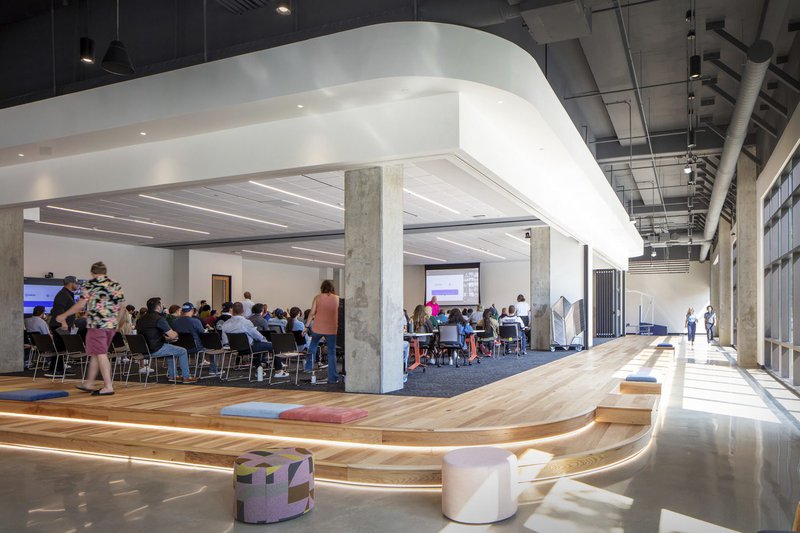 This photo features an office town hall that uses social stairs as an additional design element