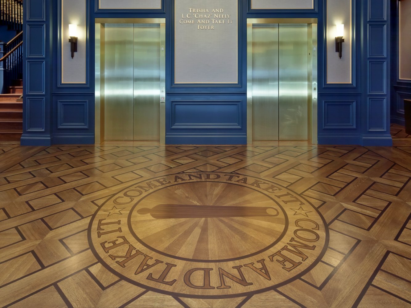 This photo features flooring with an inlay that shows how custom wood fabrication can display brand identity