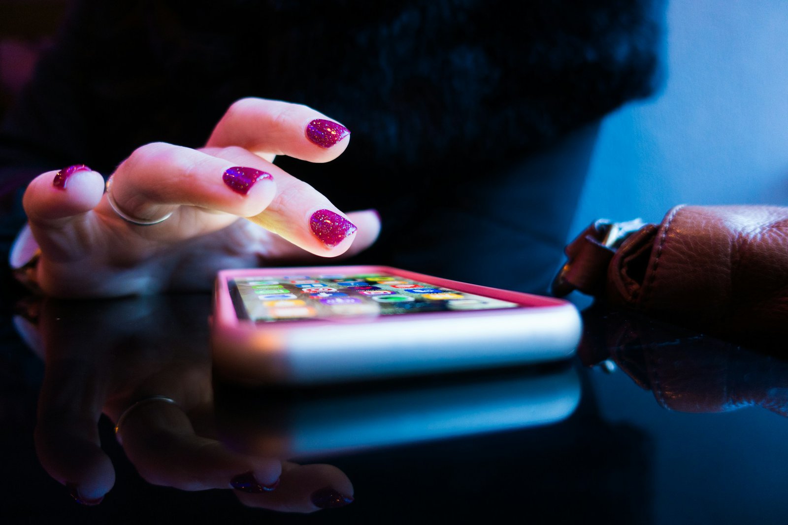 person using black smartphone with gray and pink case person using black smartphone with gray and pink case
