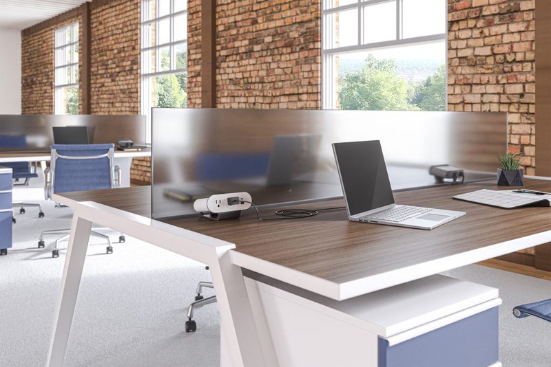 This photo features a clamp-on power unit attached to an office desk. It specifically highlights one of LightCorp's commercial power solutions for workspaces