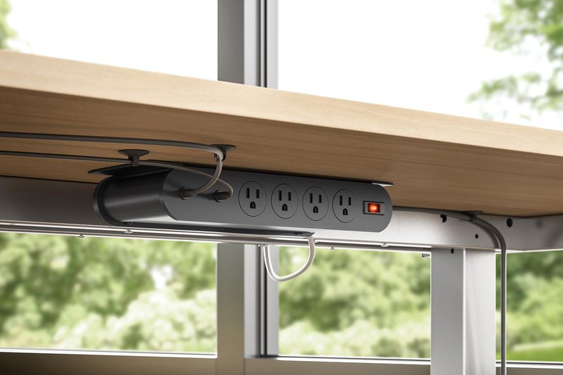 The image shows an under mount power hub installed on an office desk to provide end users with easy cable management.