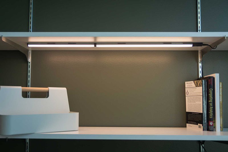 A dimly lit desk with a caddy and books on top