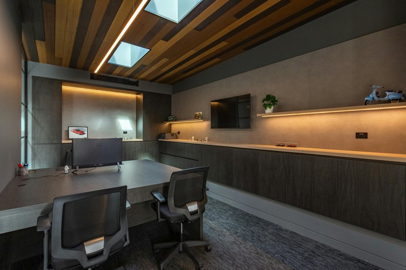 This photo features an office space with under the shelf lighting as ambient illumnation