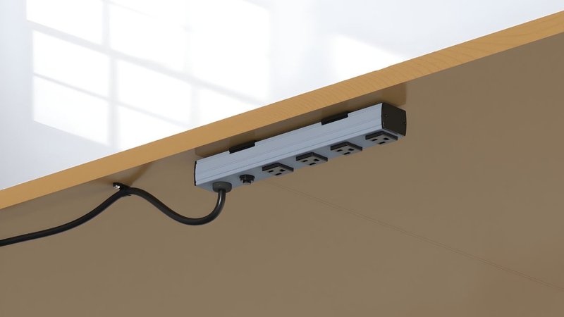 This shows a commercial power strip secured with brackets under a desk