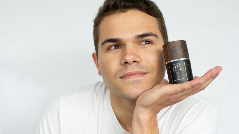 A man holding Pineapple Peel for daily or monthly exfoliation.