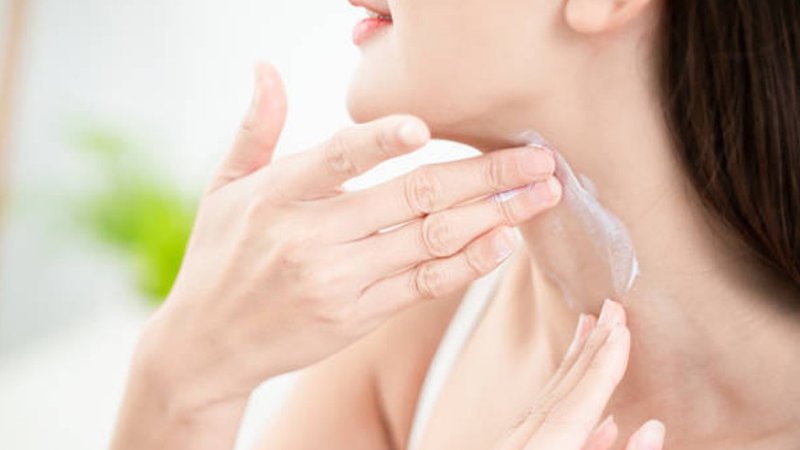 A close-up of AHA Exfoliator applied to the neck.