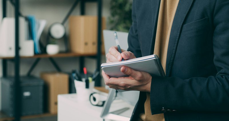 a man writing on a notebook. purchase order