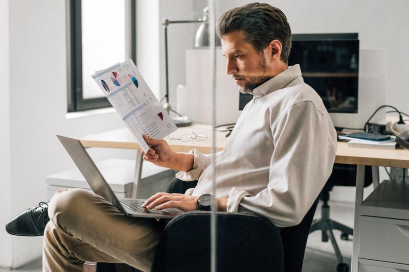 Business professional reviewing reports from multiple data sources to improve reporting accuracy.