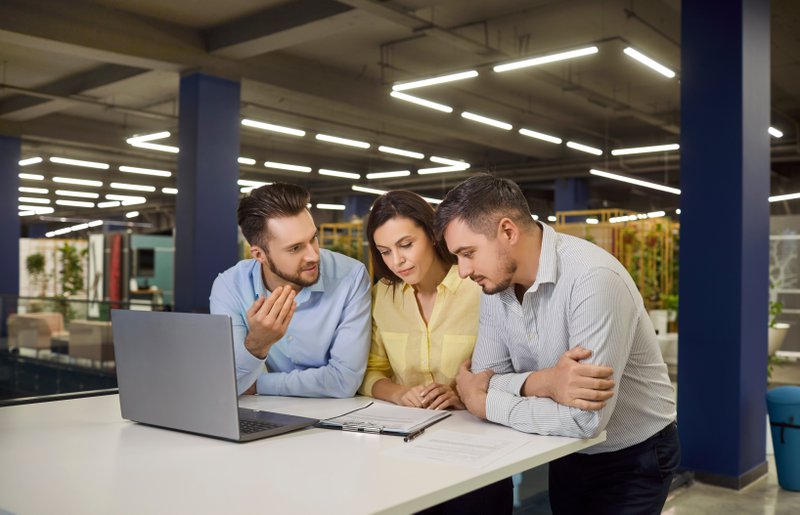 a team discussing infront of a laptop inside a furniture store