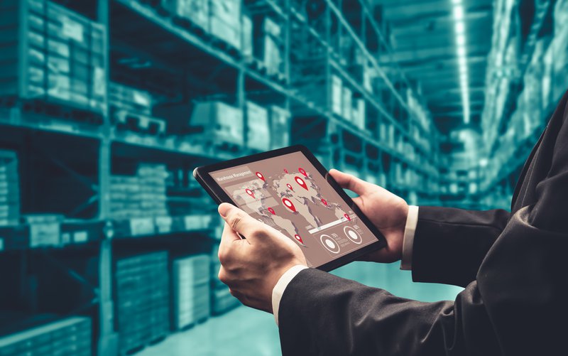 a man holding a tablet to coordinate deliveries for furniture installations