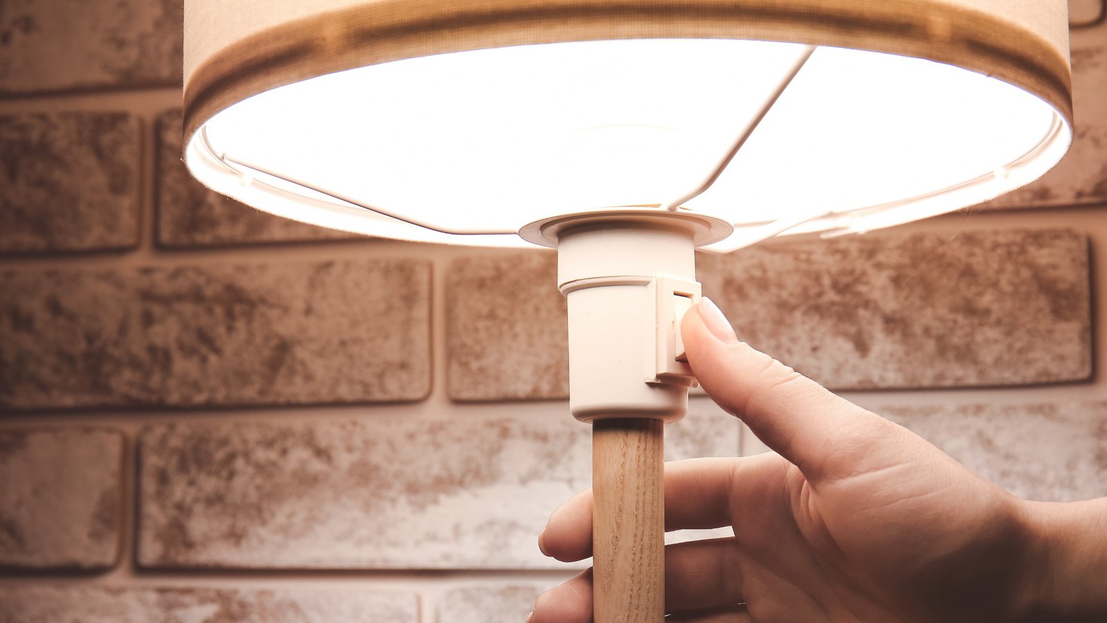 Close up of hotel guest using bedside lighting controls designed for convenient room comfort