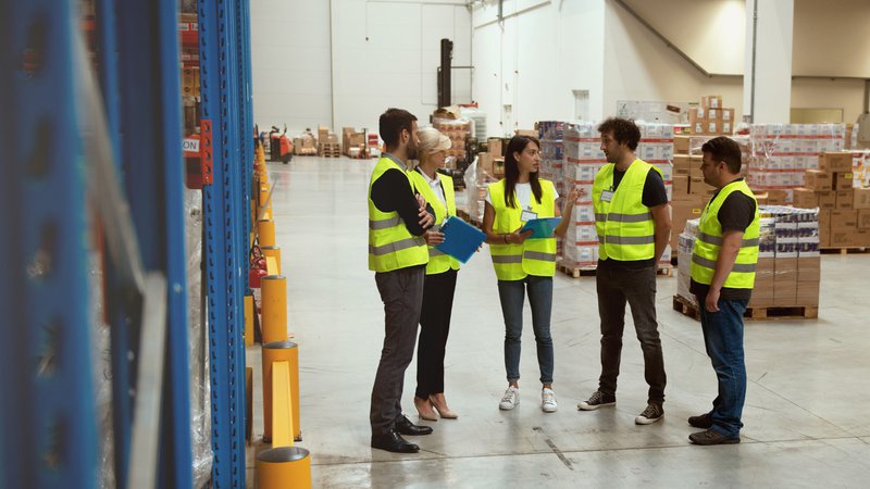 Facility manager and maintenance technician reviewing warehouse equipment performance