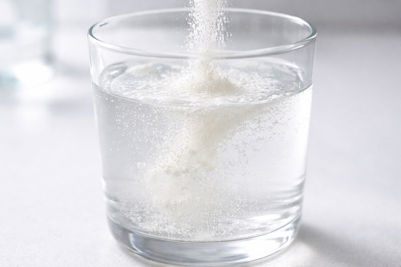 Close-up of nutrient powder dissolving into water showing gradual dispersion and mixing