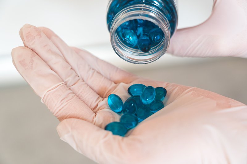 This photo shows blue digestive health supplement being poured out of a bottle