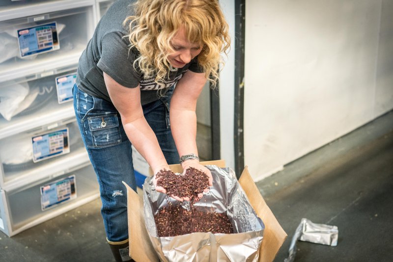 This photo features a person doing a quality check of dog food ingredients