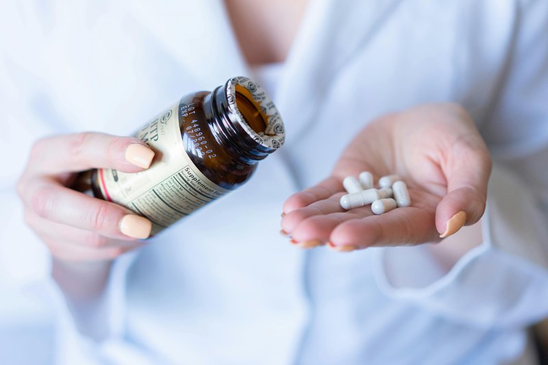 This photo showcases a woman taking organic vitamins