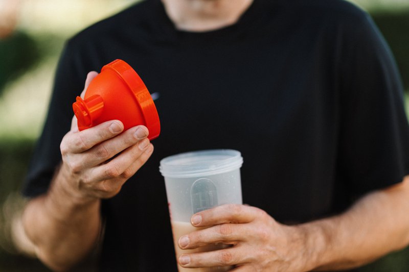 This photo features an individual drinking a protein shake with functional ingredients