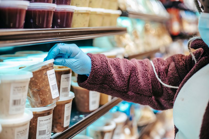This photo shows a person checking plant-based food items in the grocery
