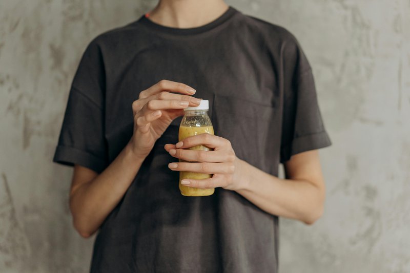 This photo shows a woman holding a probiotic drink for gut health