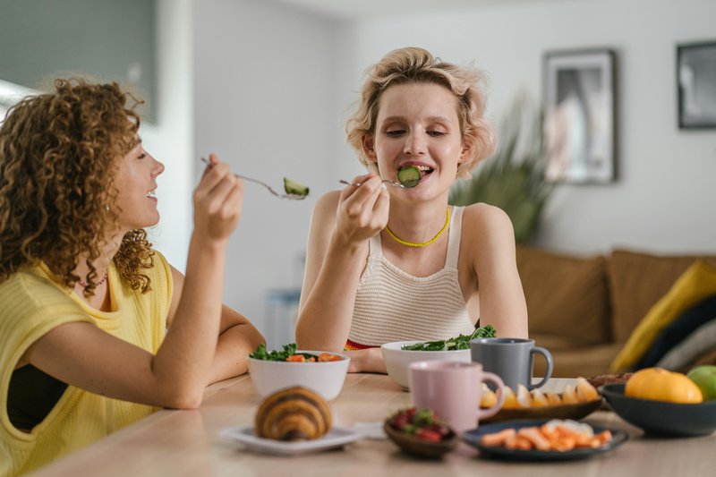 This photo features two women eating healthy for gut health