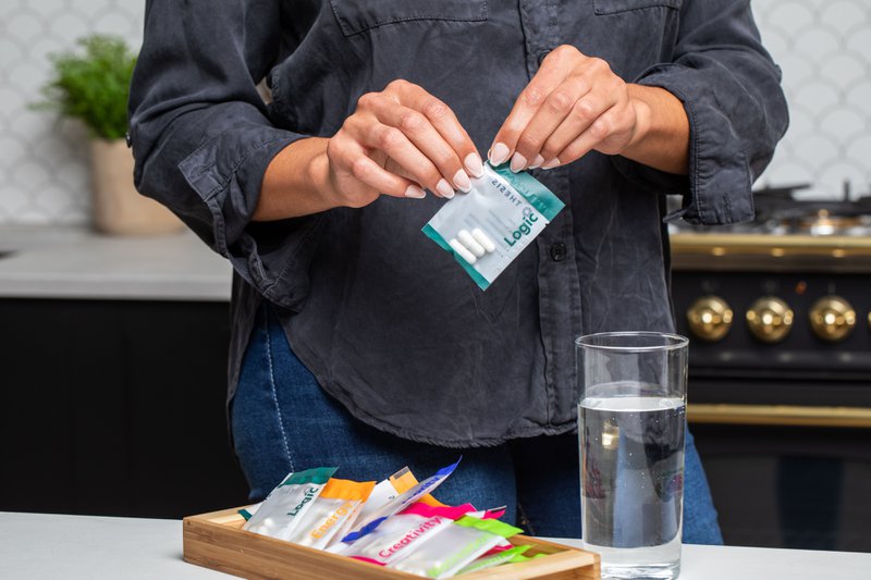 This photo features a person opening a pack of supplements