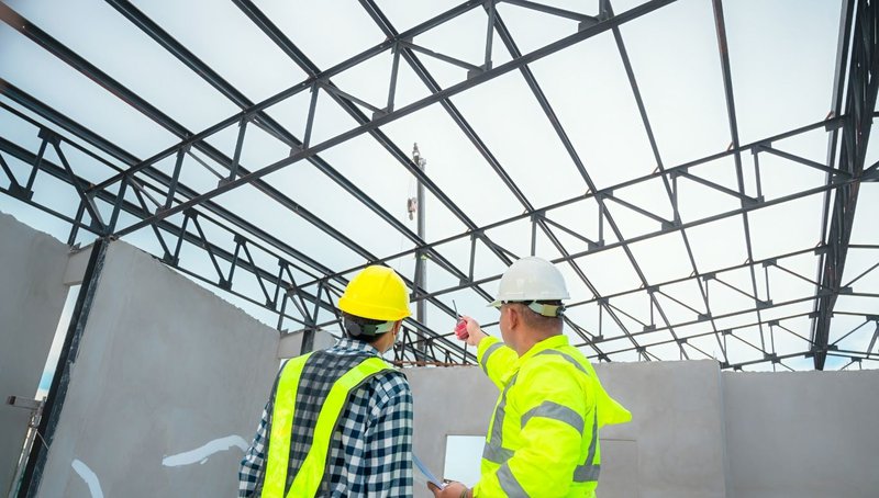 Hollow Structural Sections: How HSS Steel Supports Sustainable Building Practices 1 Construction workers inspecting a roof frame made from structural HSS Steel.